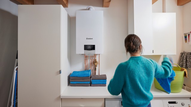 woman with back to camera in laundry room with ecoTEC plus boiler on wall