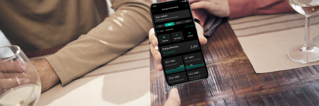 People sat at dinner table checking energy information on their smart phone
