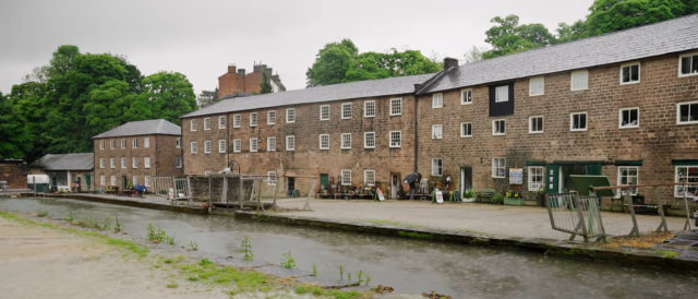 A river flows through a brick building, creating a unique scene in the heart of a bustling town.