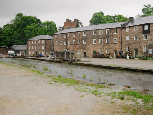 A river flows through a brick building, creating a unique scene in the heart of a bustling town.