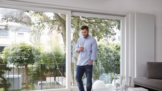 man looking at his phone in his living room