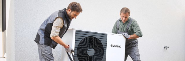 two installers fitting a heat pump