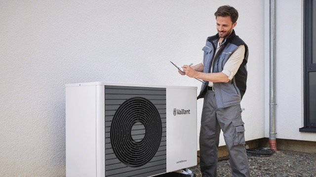 installer standing over a heat pump